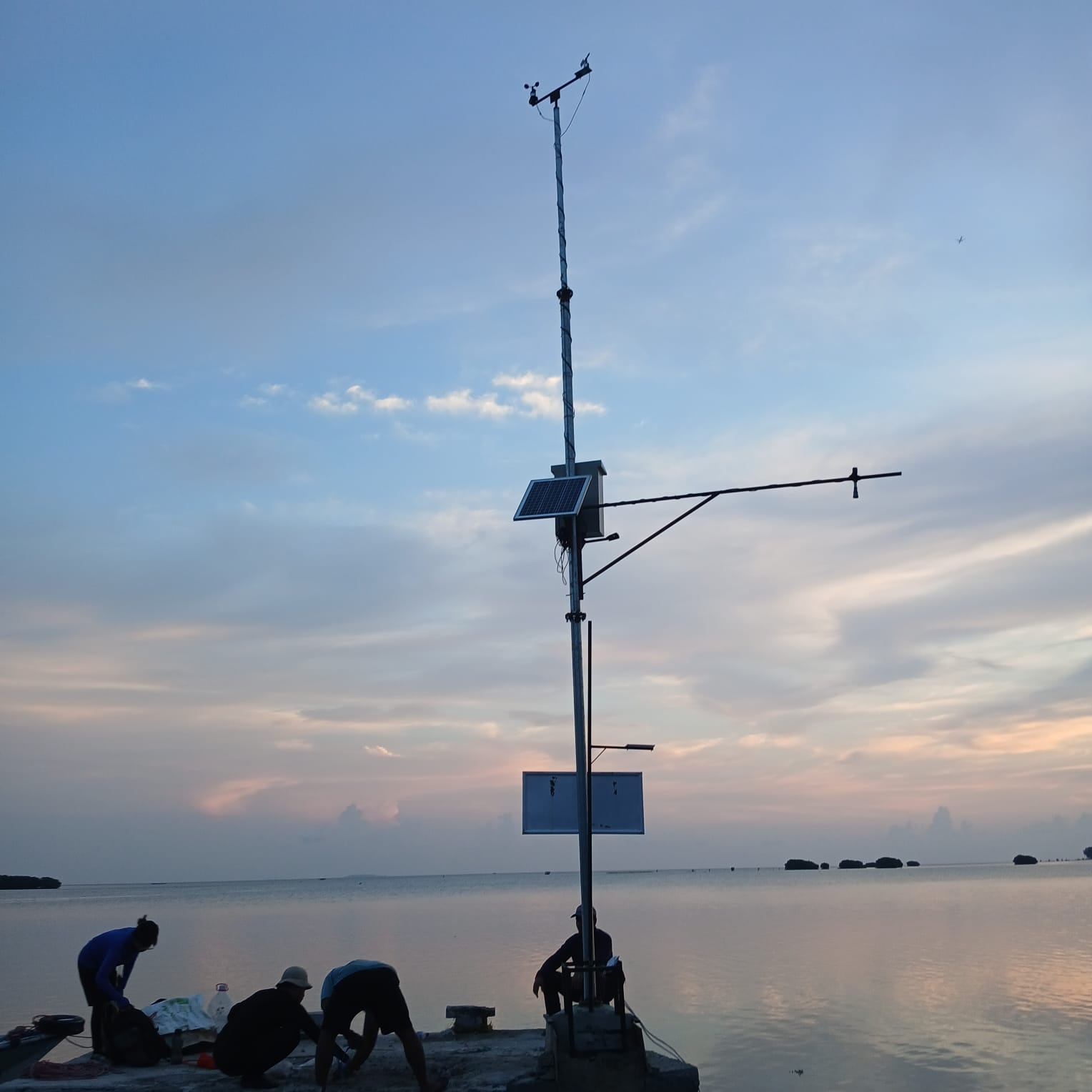Pemasangan stasiun sensor angin dan pasang surut di Pulau Pari saat senja